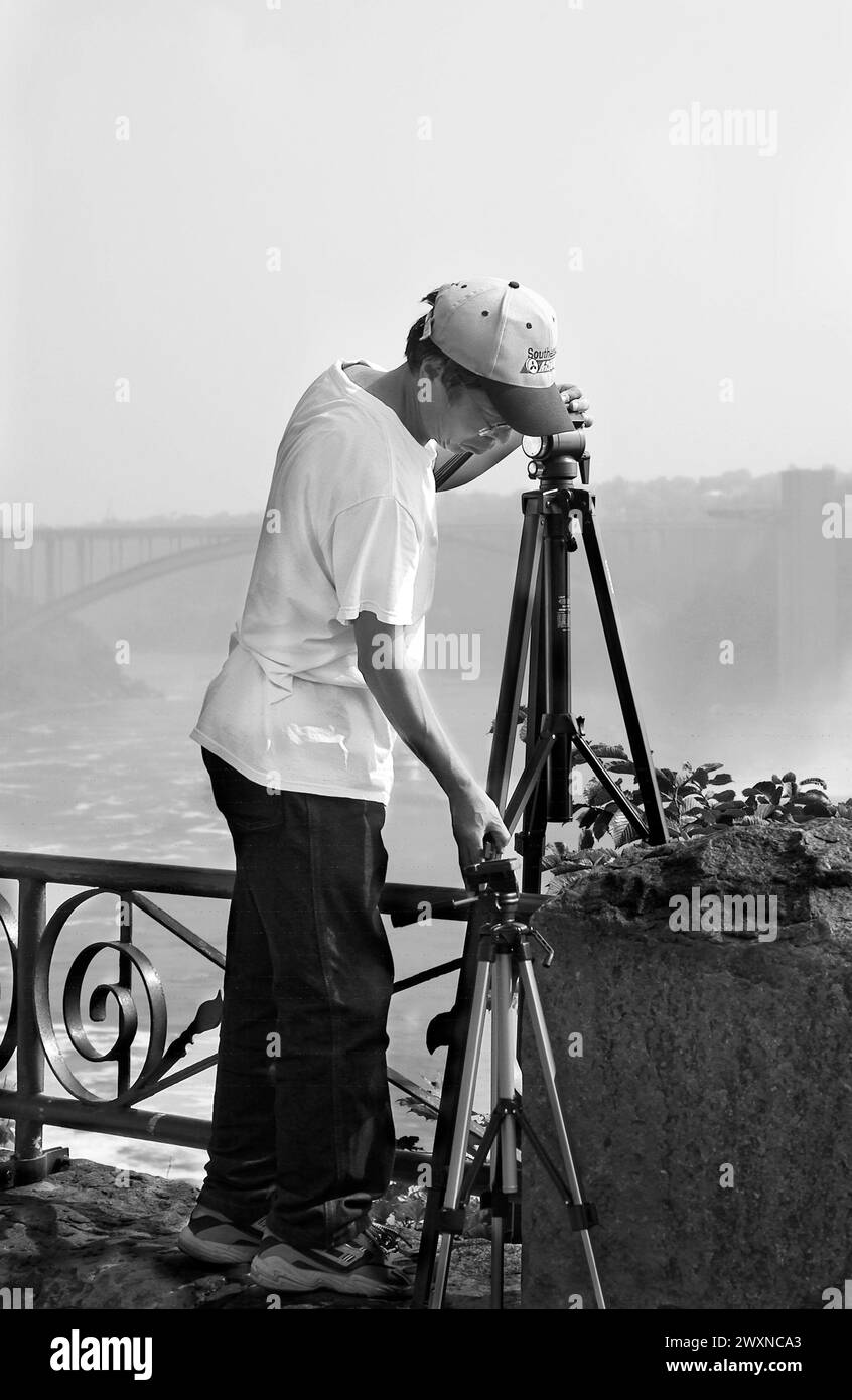 Stock photo shows Asian male photographer setting up his tripod at Niagara Falls, Canada. Stock Photo