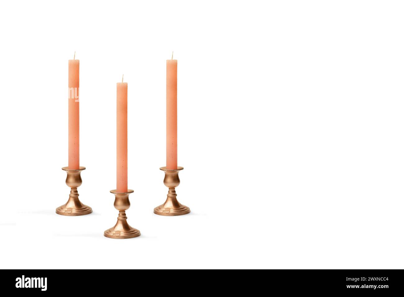 Three copper chandeliers with pink candles on a white background with copy space Stock Photo