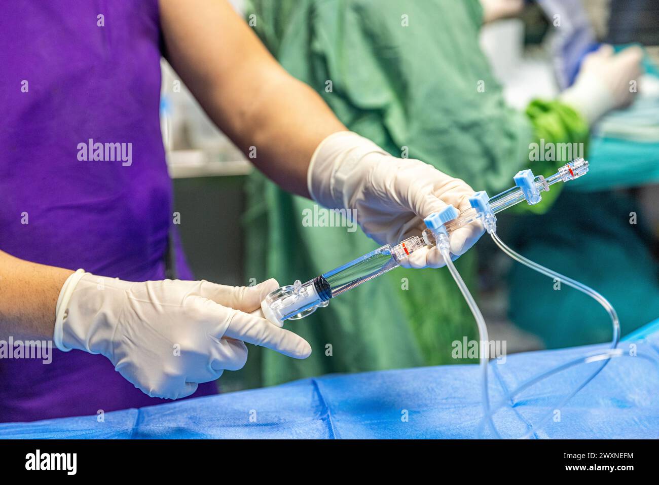 The procedure of inserting a double lumen catheter into a patient with cardiovascular occlusion in the hospital. Doctor insert double lumen catheter. Stock Photo