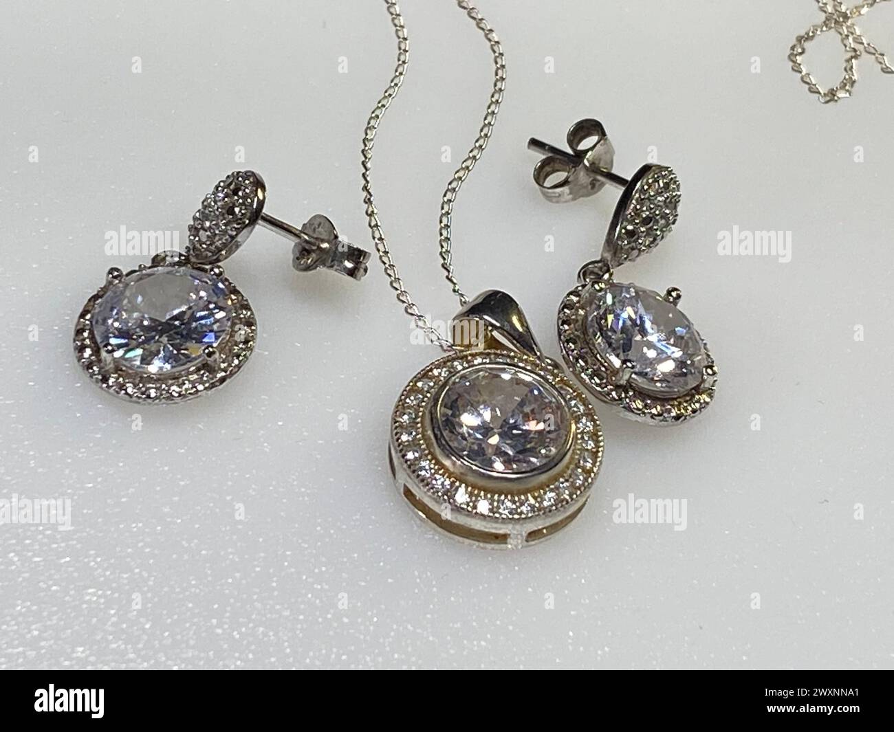 A silver necklace and earring adorned with small diamonds Stock Photo