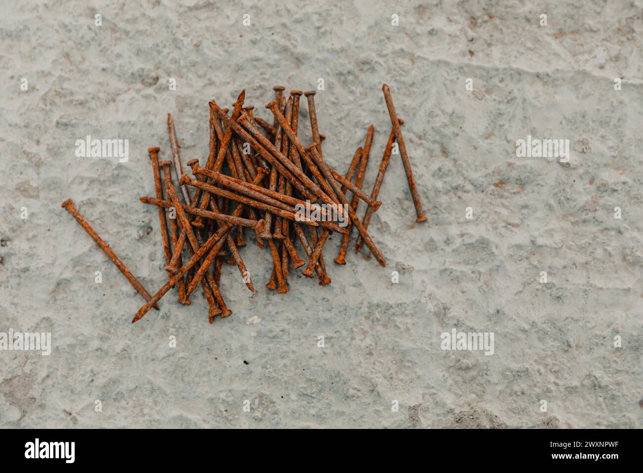 Assorted nails scattered on concrete surface Stock Photo