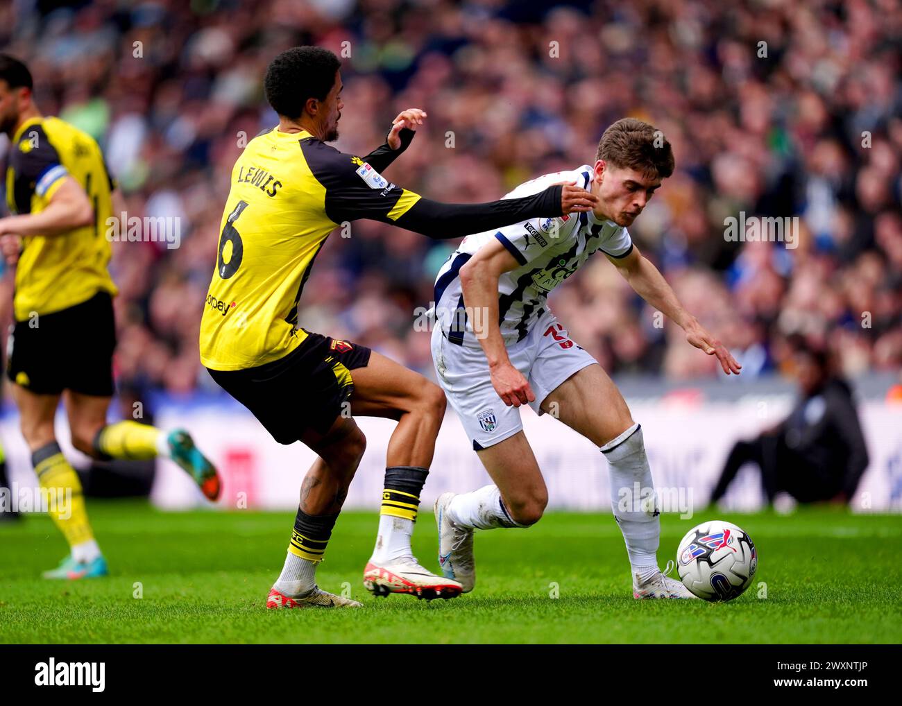 Watford's Jamal Lewis (left) and West Bromwich Albion's Tom Fellows battle for the ball during the Sky Bet Championship match at The Hawthorns, West Bromwich. Picture date: Monday April 1, 2024. Stock Photo