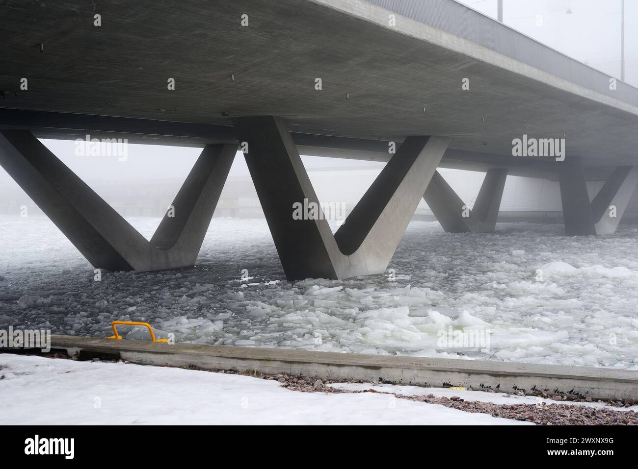 concrete bridge in heavy fog in early spring during ice drift Stock Photo