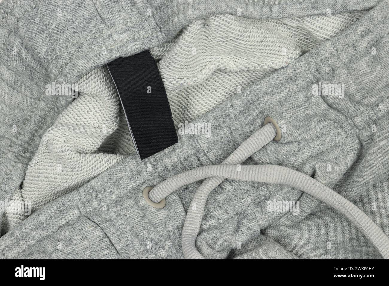 Grey tracksuit joggers sweatpants with black label tag close-up Stock Photo