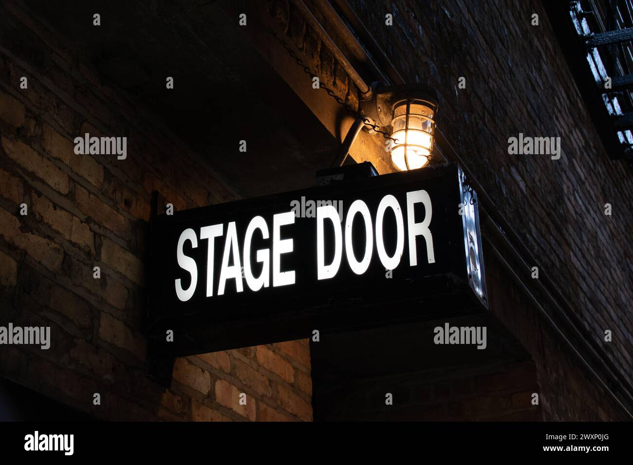 Vintage illuminated stage door sign in a dark and dingy back alley in ...