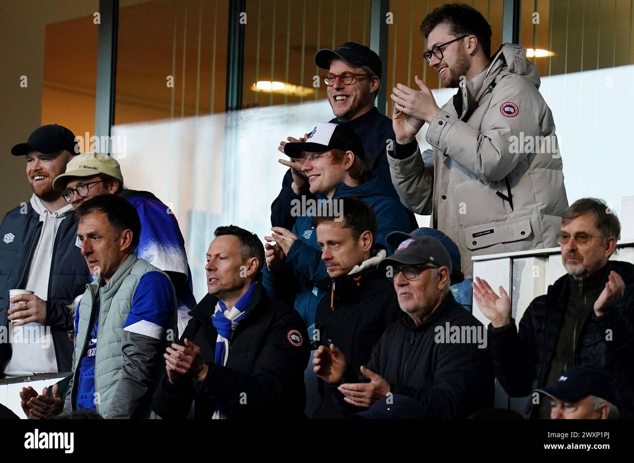Ipswich Town fan Ed Sheeran (centre) applauds his side's second goal in the stands during the Sky Bet Championship match at Portman Road, Ipswich. Picture date: Monday April 1, 2024. Stock Photo