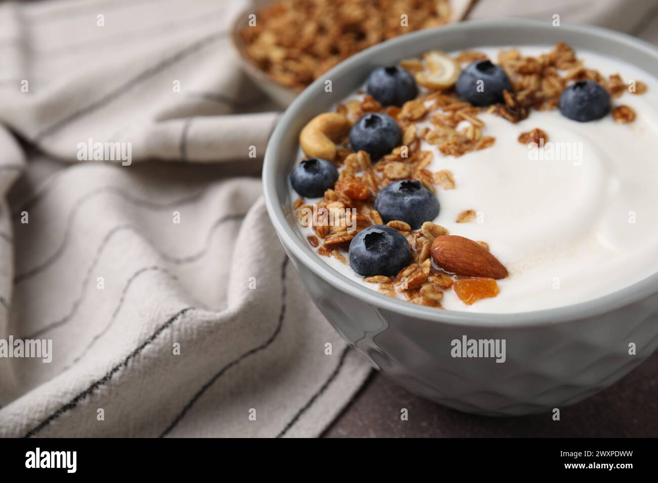 Bowl with yogurt, blueberries and granola on grey table, closeup Stock Photo
