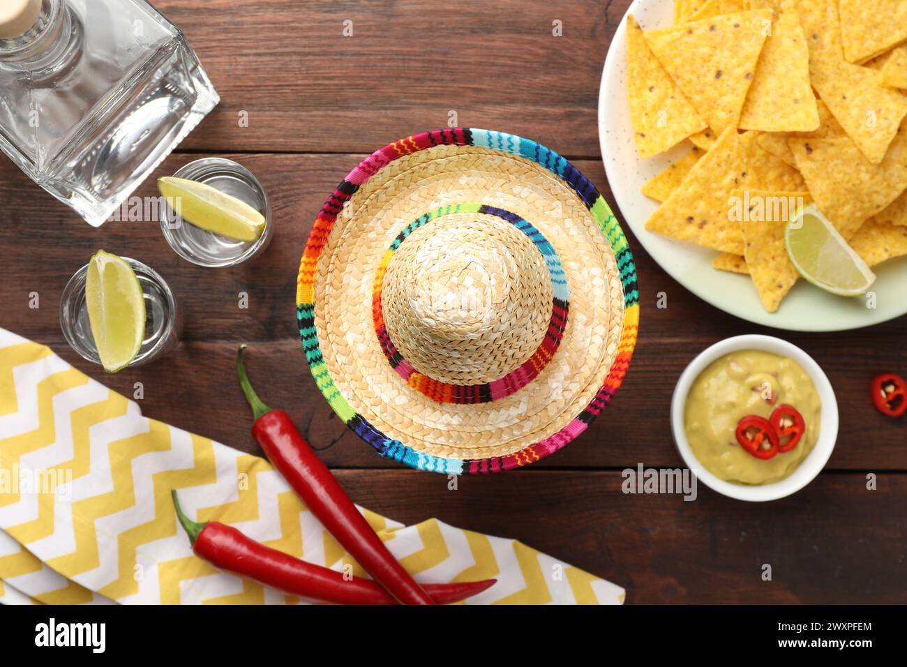 Mexican sombrero hat, tequila with lime, chili peppers, nachos chips ...