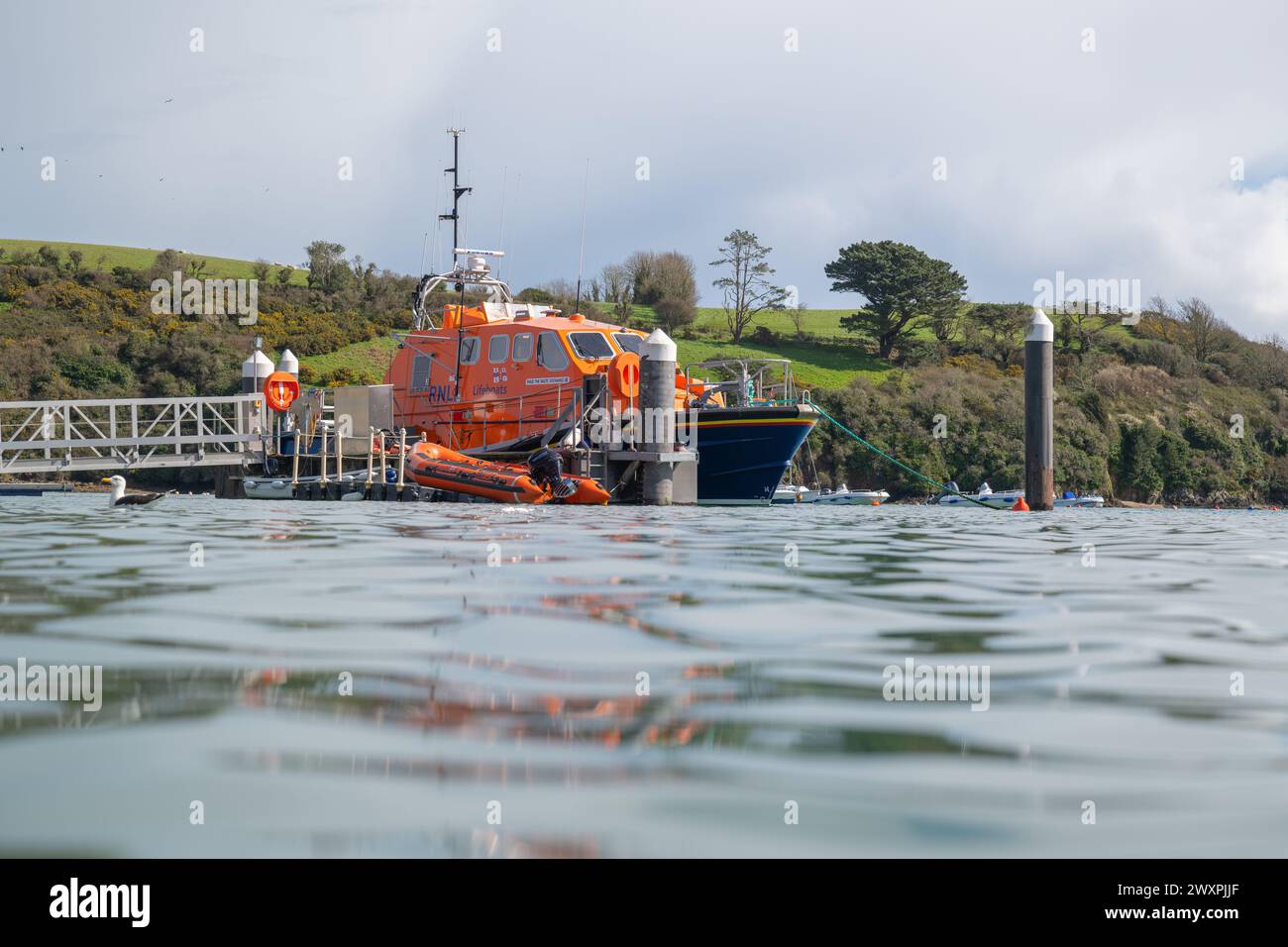 View of Salcombe all weather lifeboat, The Baltic Exchange III, taken from a low angle on harbour wall, with Snapes Point in the background iii. Stock Photo