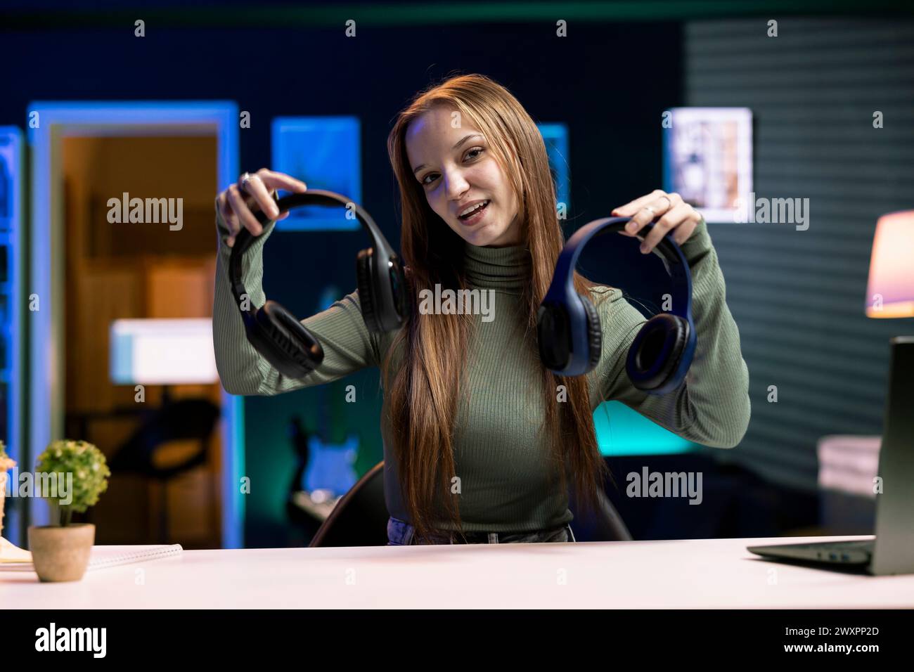Cheerful gen Z influencer in studio films headphones comparison video ...