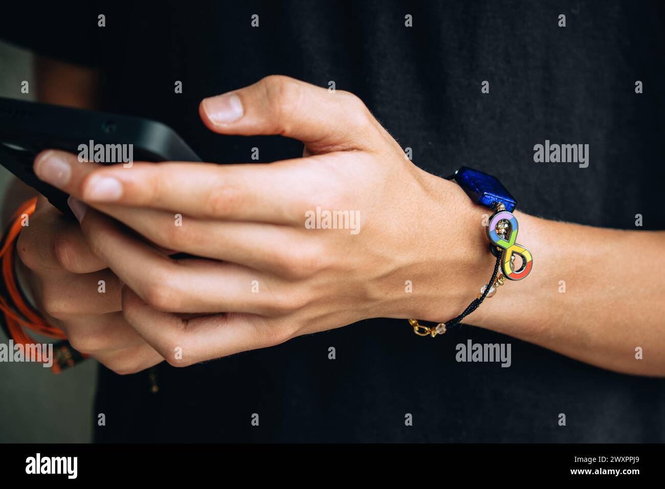 Teenage boy with wristlet with autism infinity rainbow symbol sign on ...