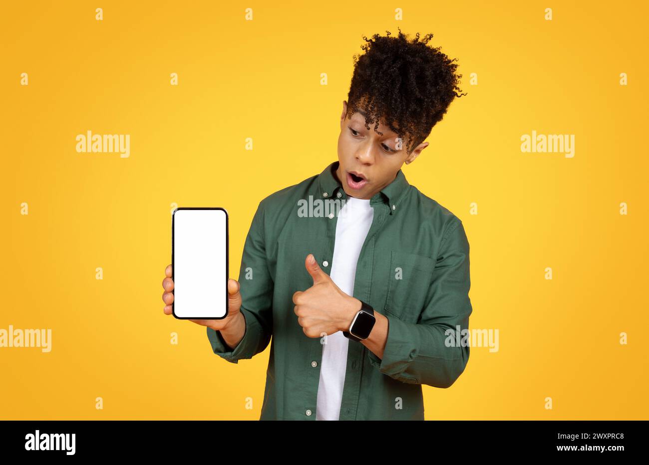 Surprised young man holding smartphone Stock Photo