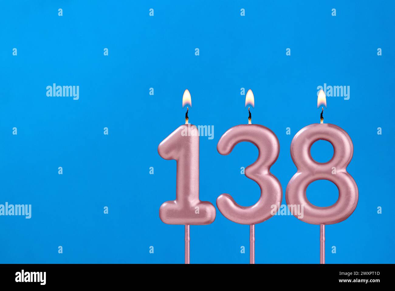 Number 138 - Burning anniversary candle on blue foamy background Stock Photo - Alamy