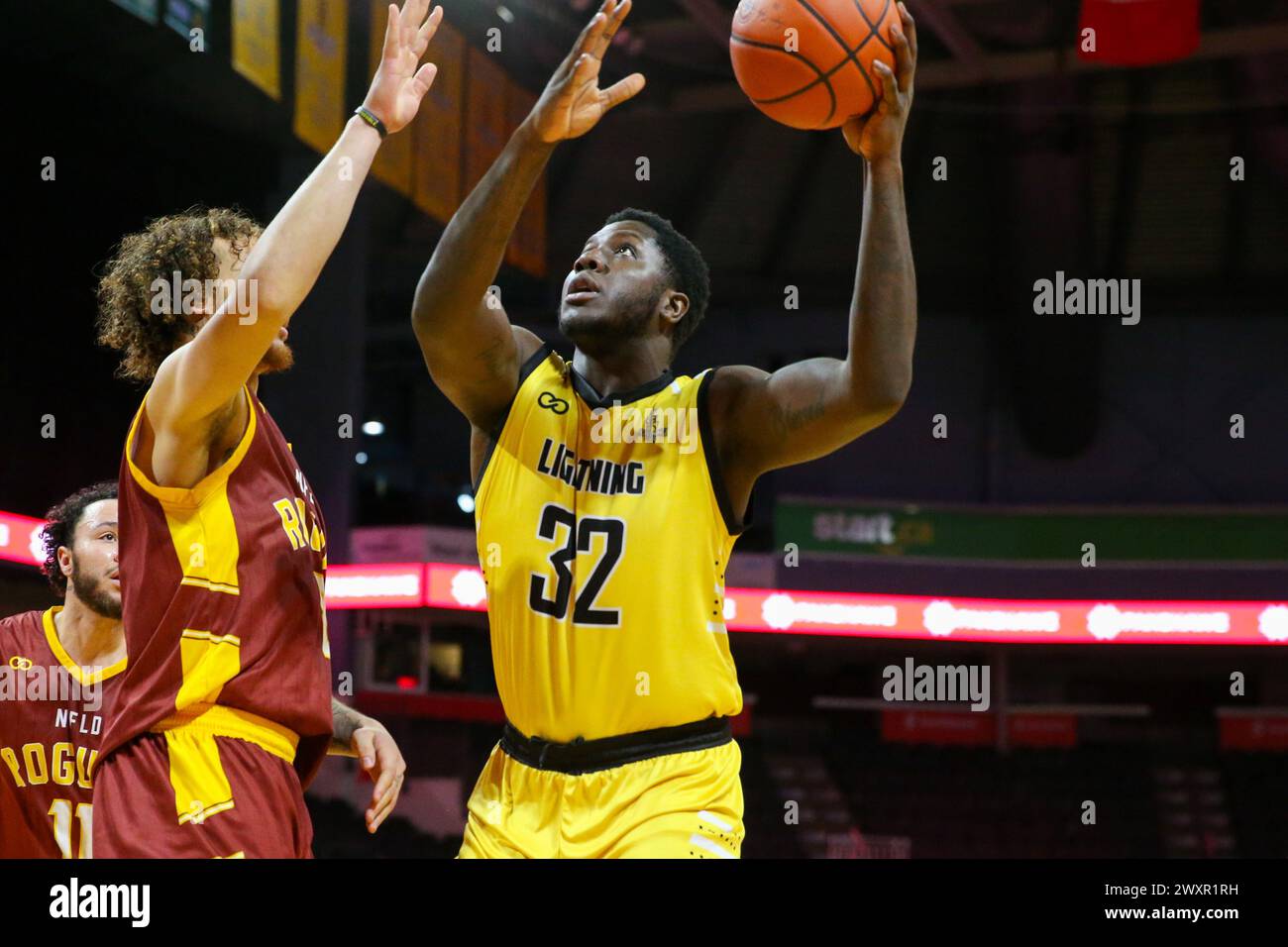 London, Canada. 1st Apr, 2024. The London Lightning lead the Newfoundland Rogues 60-56 at half time. Drew Gordon (32) of the London Lightning takes a shot under pressure from Lewis Djonkam (8) of the Newfoundland Rogues during the second quarter. Credit: Luke Durda/Alamy Live News Stock Photo