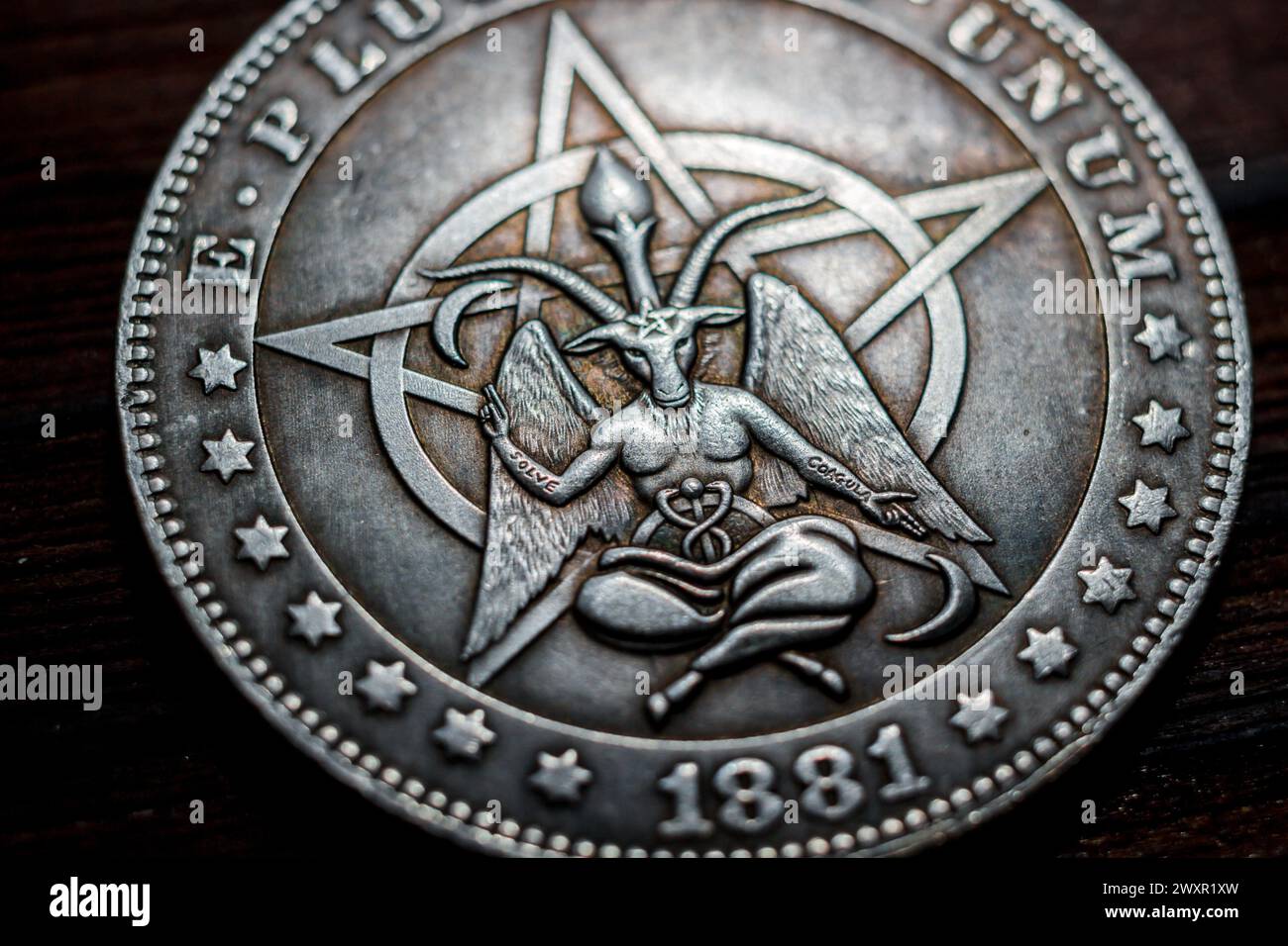 Souvenir coin with the image of a baphomet close-up. Inscription Solve Coagula on Latin Stock Photo