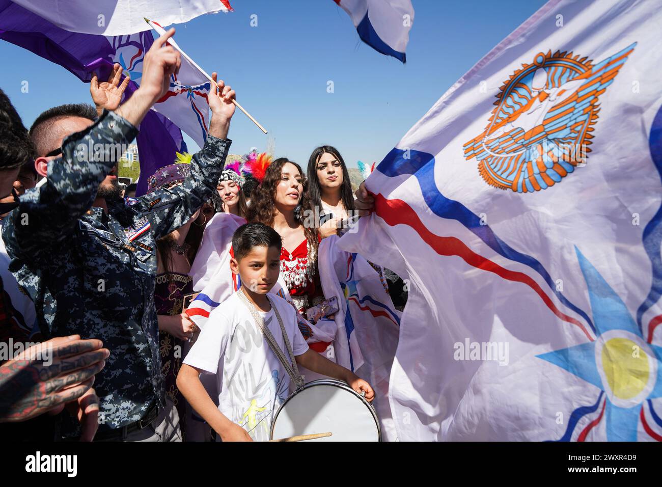 Dohuk, Iraq. 01st Apr, 2024. Assyrians dance to the tunes of a musical band, carrying flags during Aketo celebrations, the Assyrian New Year 6774, in Dohuk. Credit: SOPA Images Limited/Alamy Live News Stock Photo