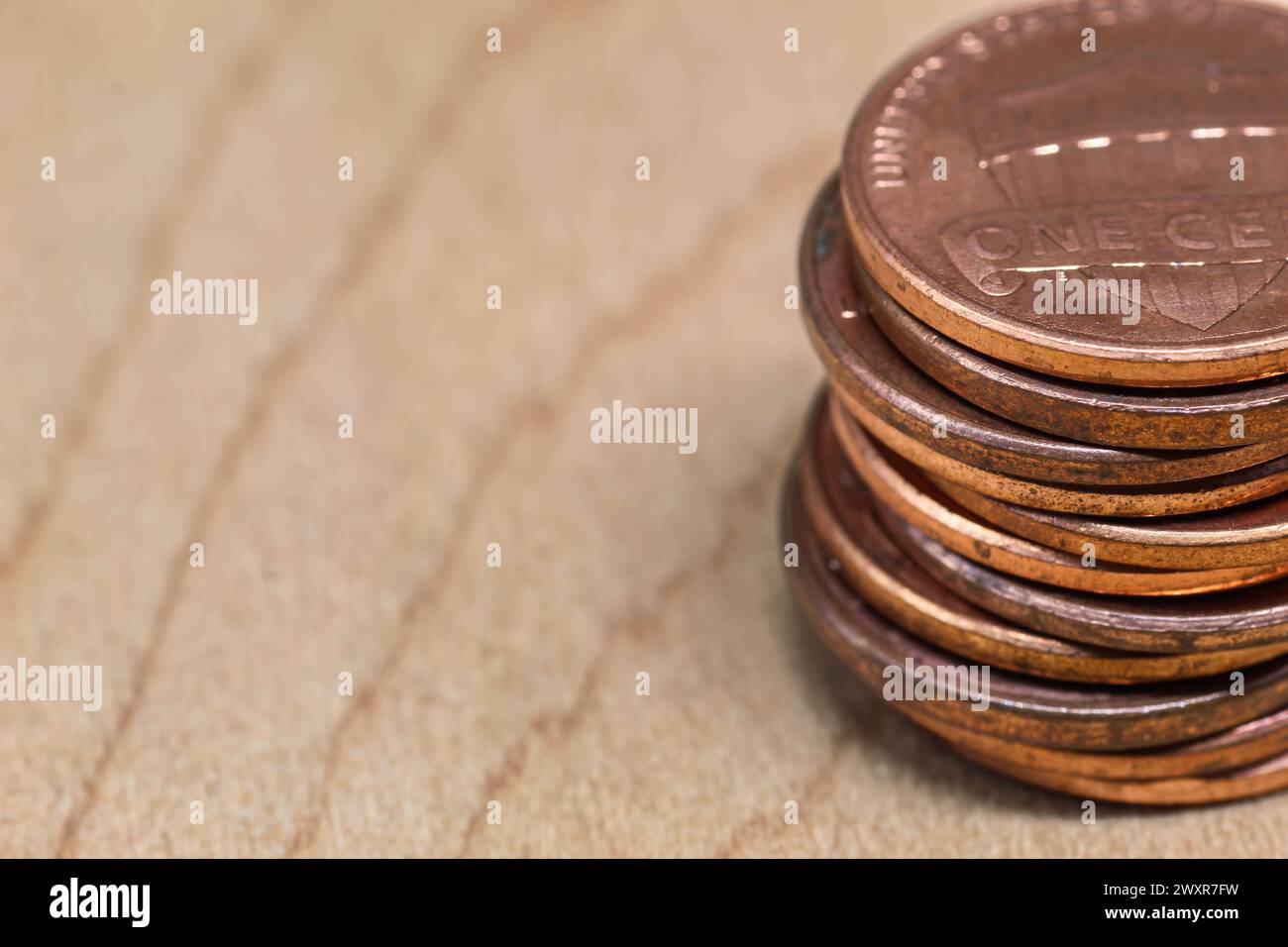 column of old one cent coins on wooden surface Stock Photo