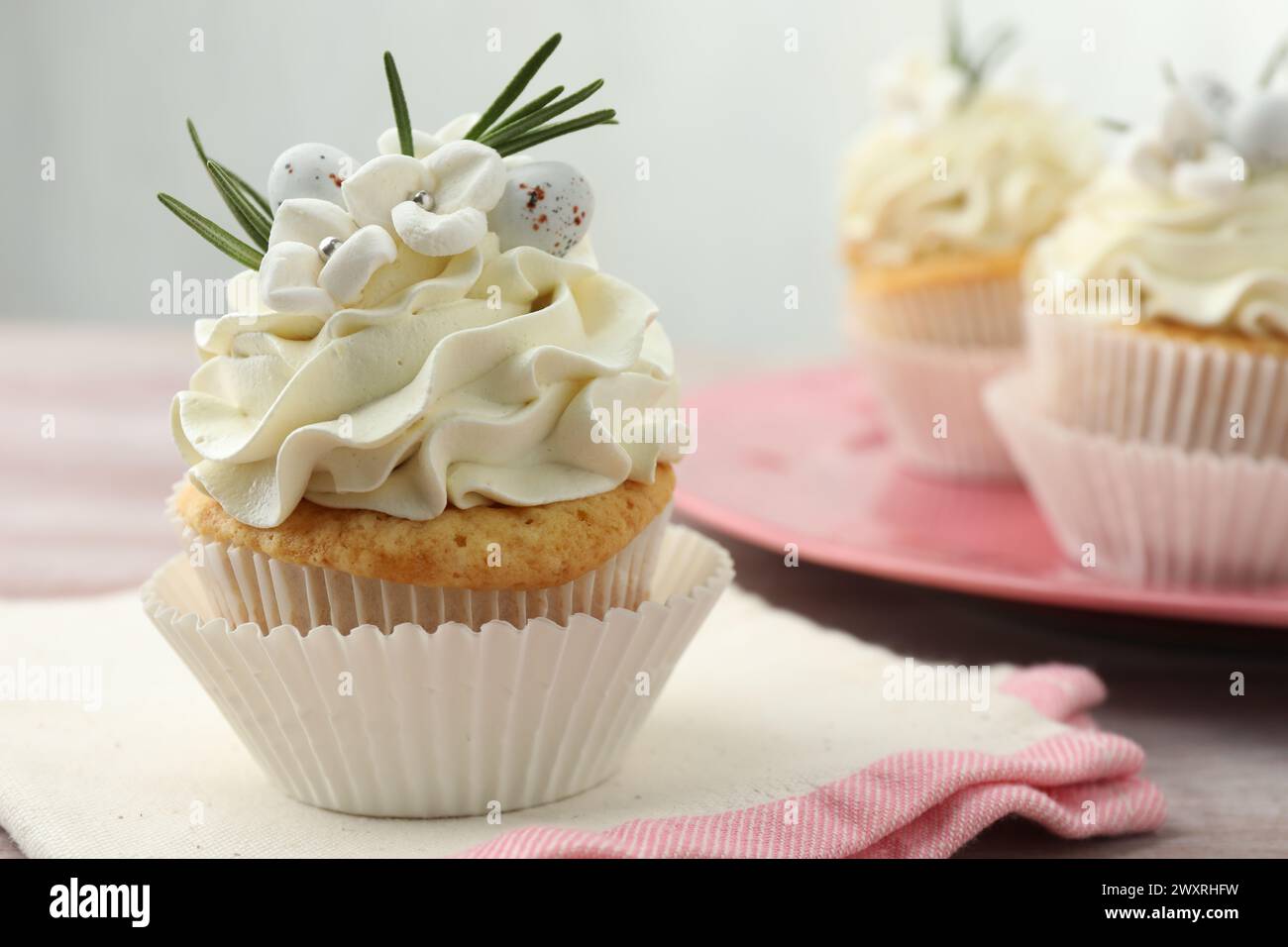 Tasty Easter cupcakes with vanilla cream on table Stock Photo