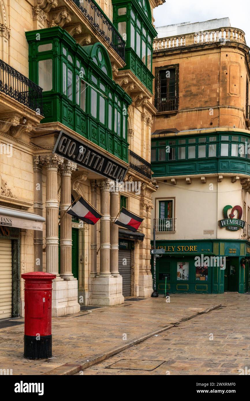 Valletta, Malta - 23 December, 2023: typical street in downtown Valletta with green Gallarija balconies and British influence Stock Photo