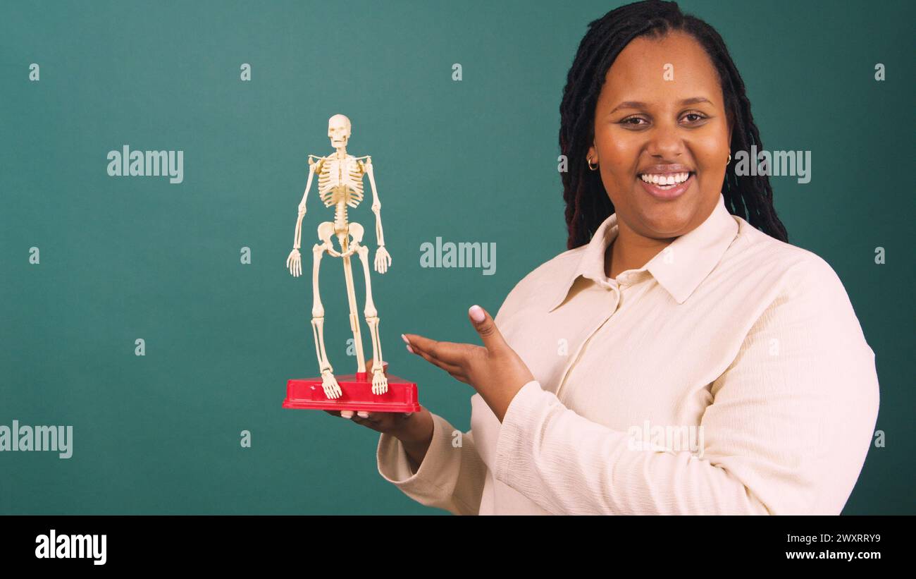 Young Black female doctor teaches human anatomy with model skeleton