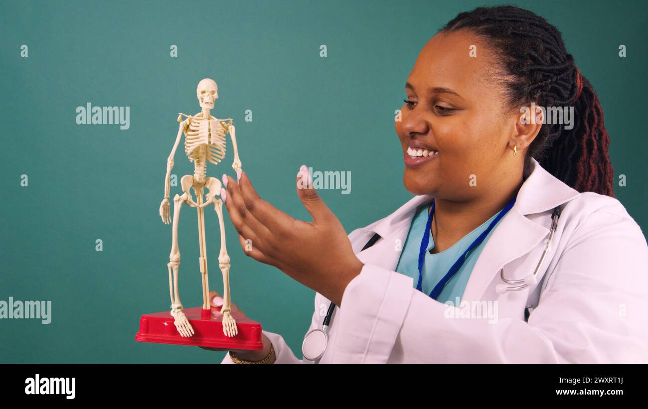 Young Black female doctor teaches human anatomy with model skeleton