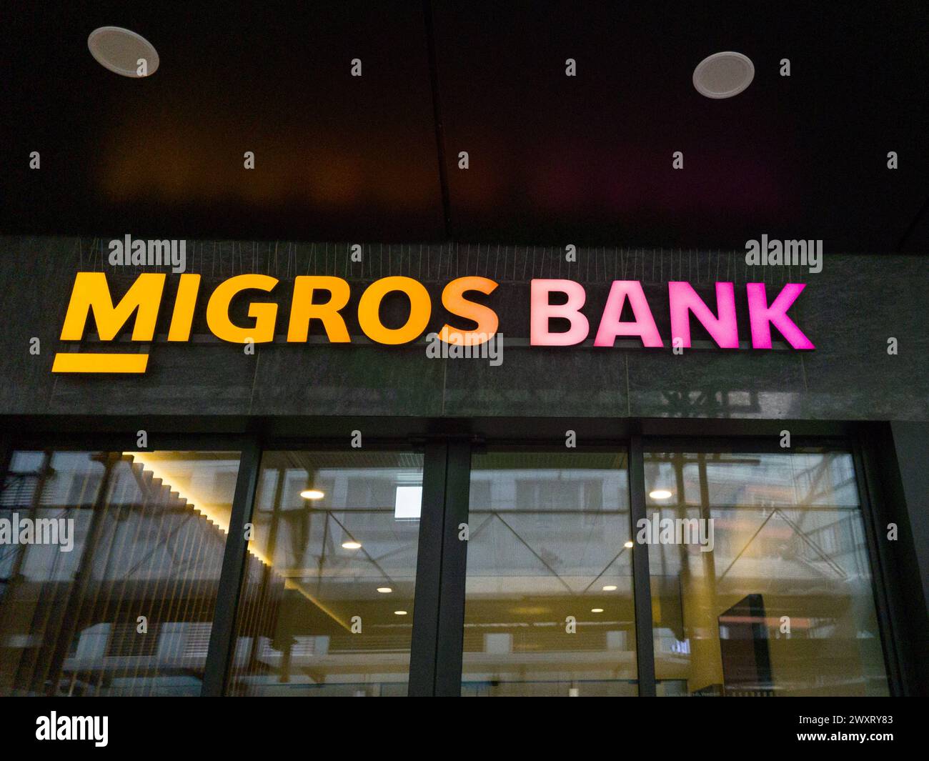 The Migros bank logo on the façade of a branch in Bienne, Switzerland, on March 29, 2024. Photo by Laurent Coust/ABACAPRESS.COM Credit: Abaca Press/Alamy Live News Stock Photo