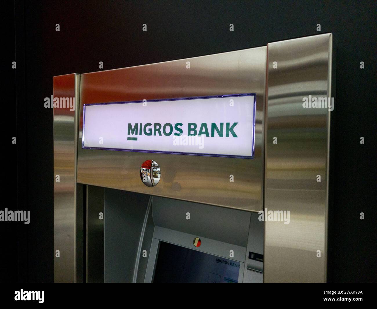 The Migros bank logo on a cash dispenser in Biel, Switzerland, March 29, 2024. Photo by Laurent Coust/ABACAPRESS.COM Credit: Abaca Press/Alamy Live News Stock Photo