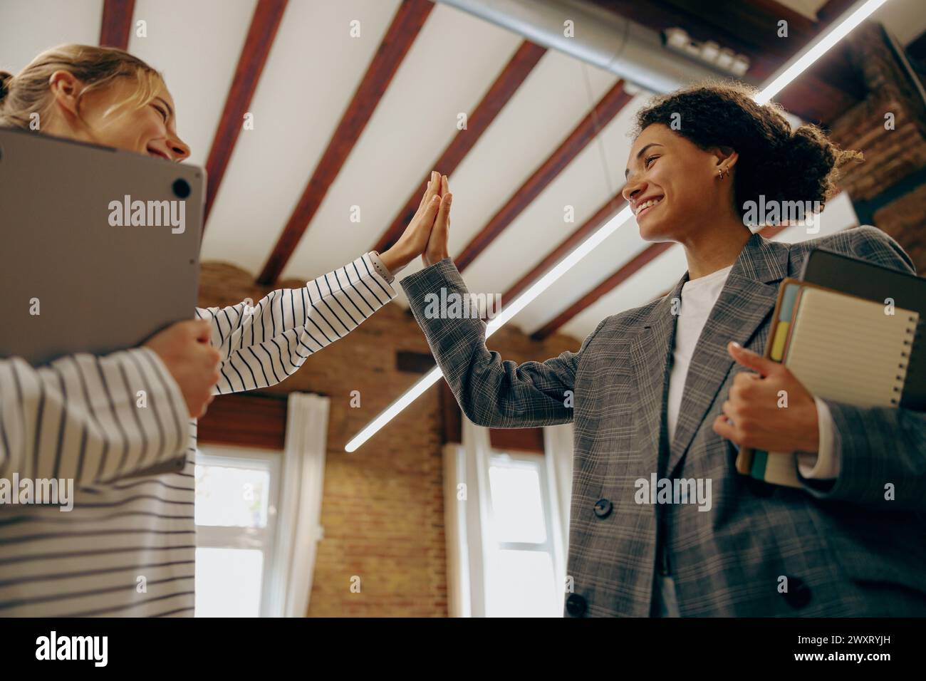 Successful business people giving each other a high five in a meeting ...