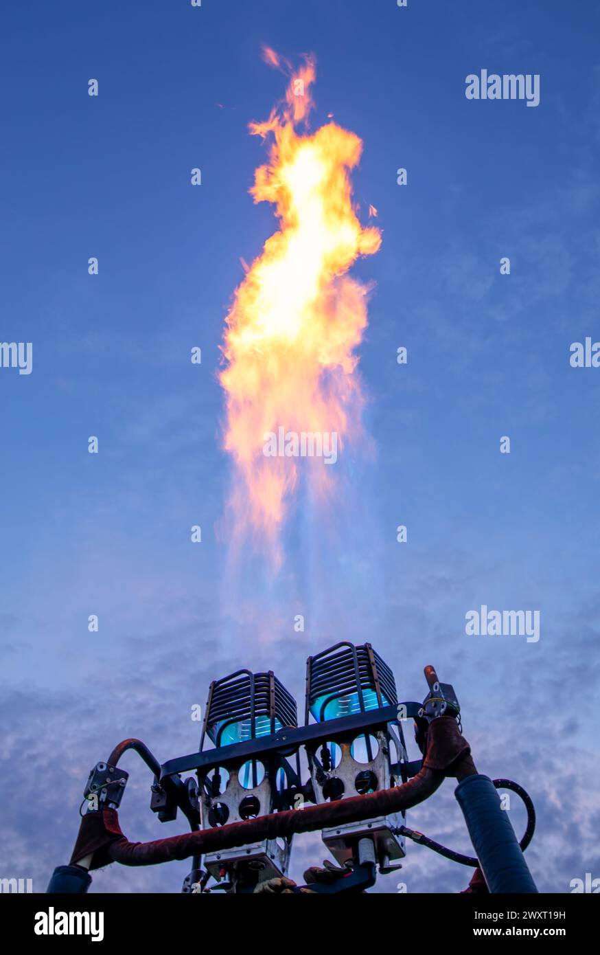 Ethereal Flames: Gas Burner Fire Illuminating the Evening Sky Stock Photo
