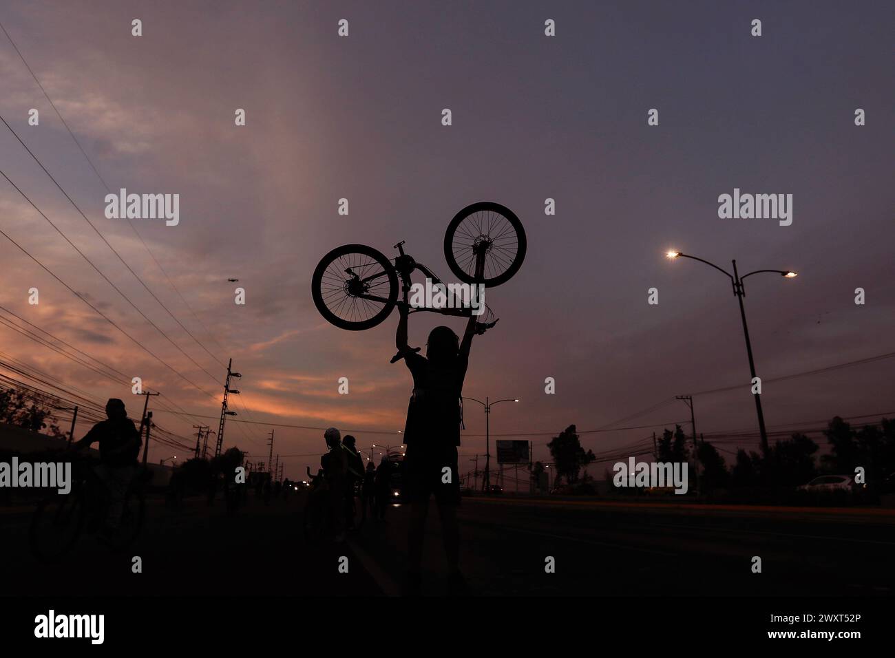 A cyclist raises his bicycle during a demonstration. The Union of Cycling Associations of Querétaro, together with representatives of various groups of people with disabilities, pedestrians and public transport users, held a demonstration on Paseo 5 de Febrero, to demand, through a human cycle path, a walk and a ride, that Consider in the mega project (which has not yet completed its construction and in which more than 6 billion pesos were invested) the conditions for sustainable mobility and that only car users are not prioritized. Stock Photo