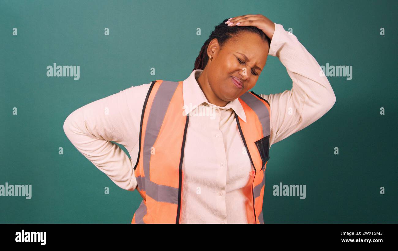 Young Black manager experiencing backache pain on construction site Stock Photo