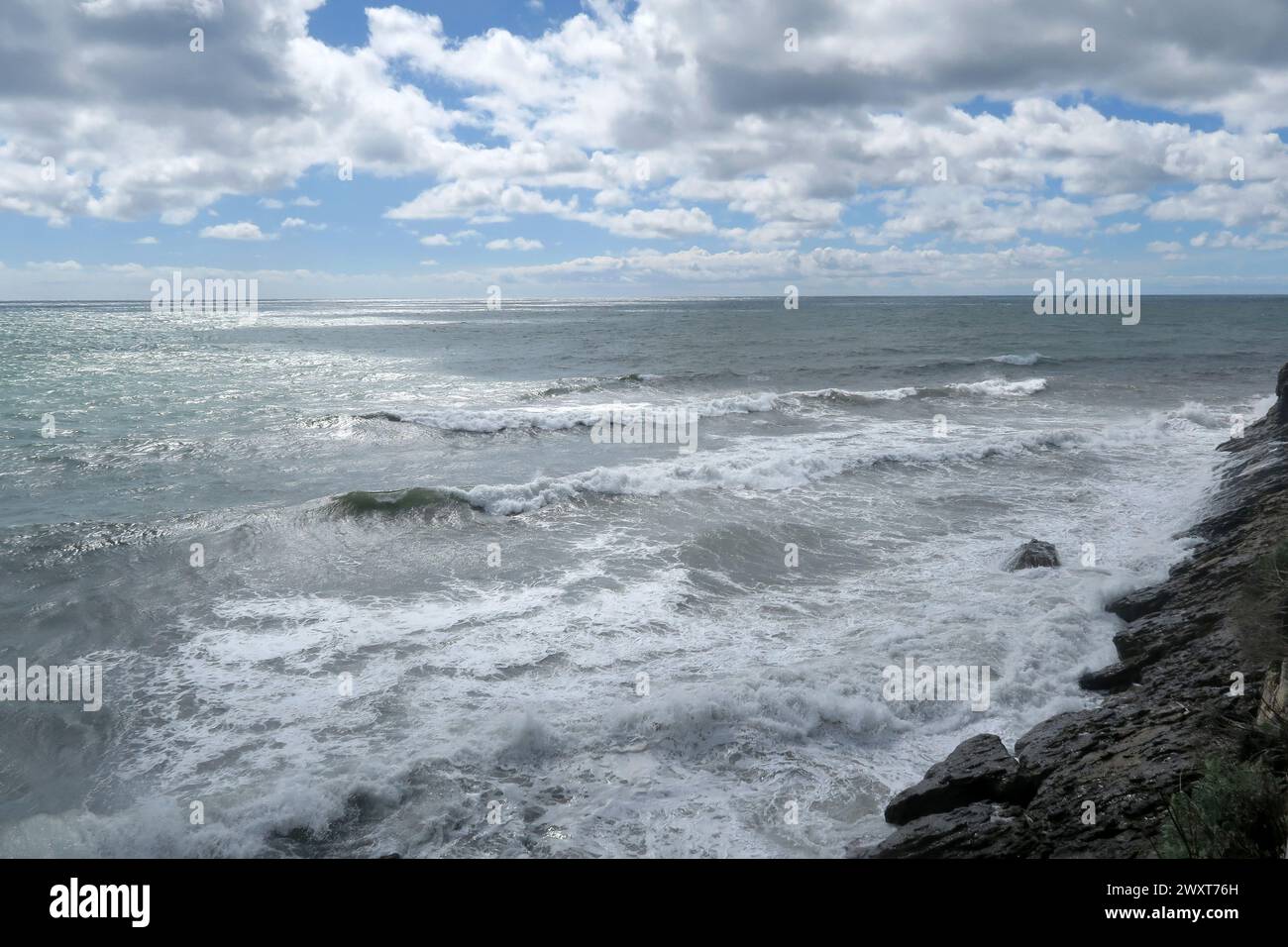 Some waves crashing onto sandy beach shore Stock Photo