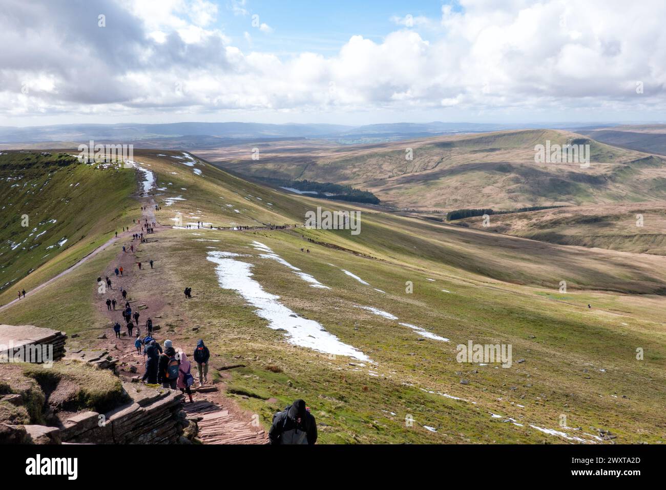 Brecon Beacons, Wales: A trail of outdoor walkers make their way up a busy route to the side of Corn Du and Pen Y Fan from the National Trust car park Stock Photo