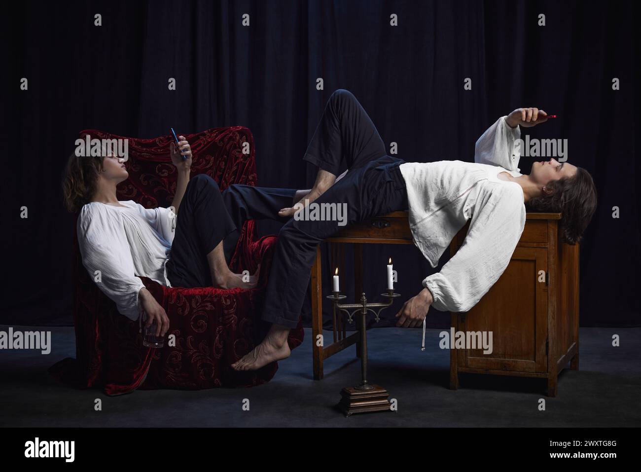 Two men, poets dressed in old-fashion clothes using modern smartphones