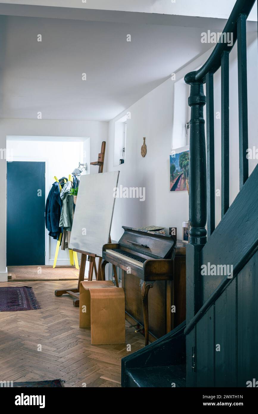 Teal paintwork and piano in entrance hall of East London home, UK Stock Photo