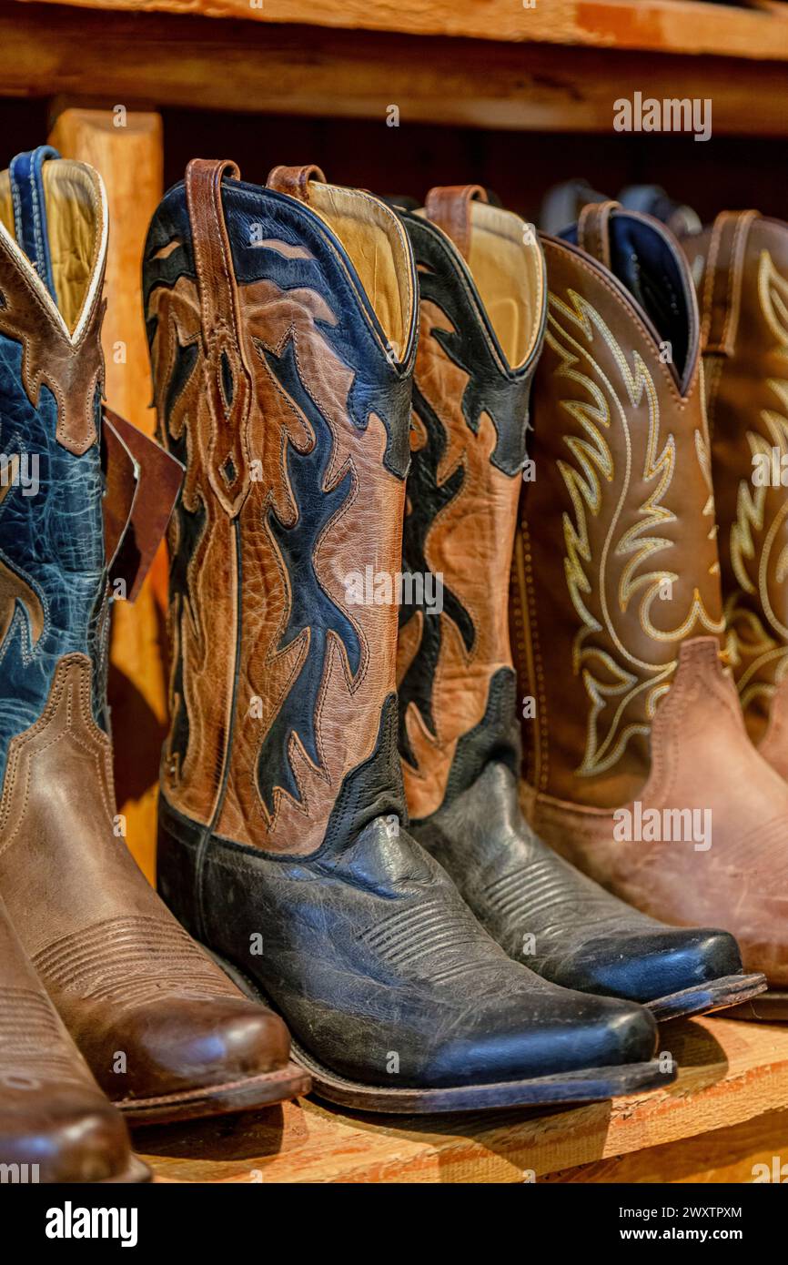 Cowboy boots in a store. Close-up of new cowboy boots on shelf. Aligned ...