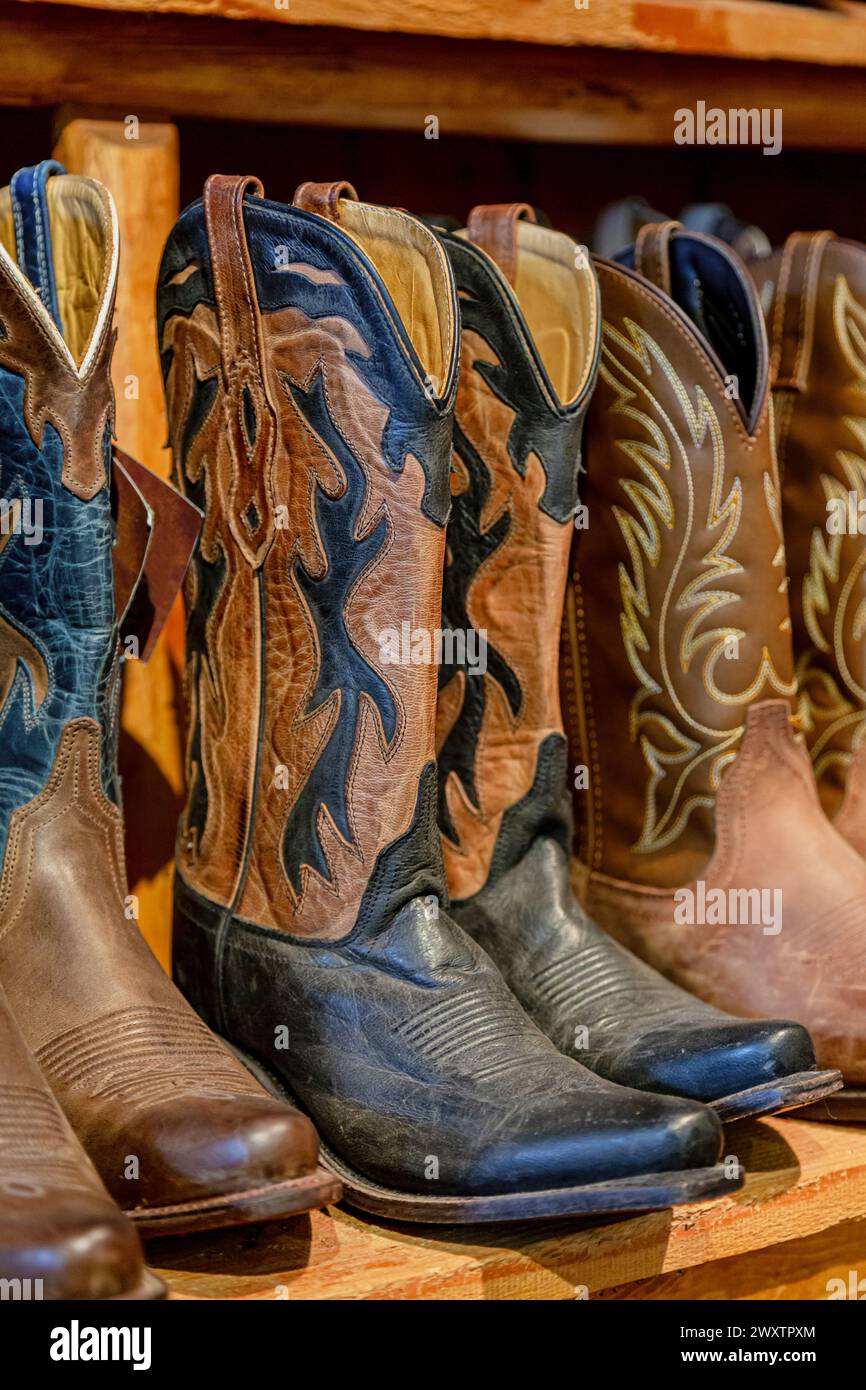 Cowboy boots in a store. Closeup of new cowboy boots on shelf. Aligned