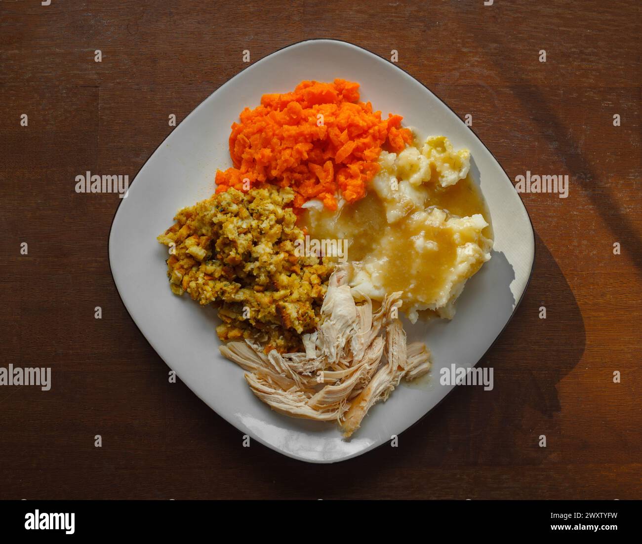Turkey dinner on a white plate with potatoes, gravy, stuffing and carrots Stock Photo