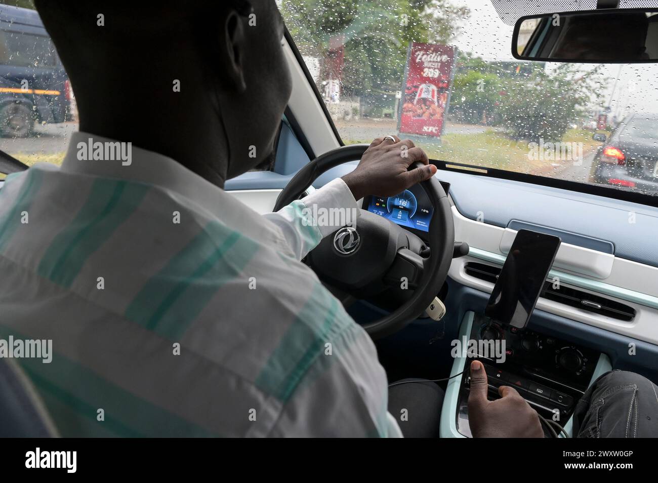 GHANA, Accra, electric mobility, Taxi and Bolt driver Frederick drives a from startup IJANU leased chinese Dongfeng EX1 electric car / GHANA, Accra, E-Mobilität, Taxi und Bolt Fahrer Frederick fährt ein von dem startup IJANU geleastes chinesisches Dongfeng EX1 E-Auto Stock Photo