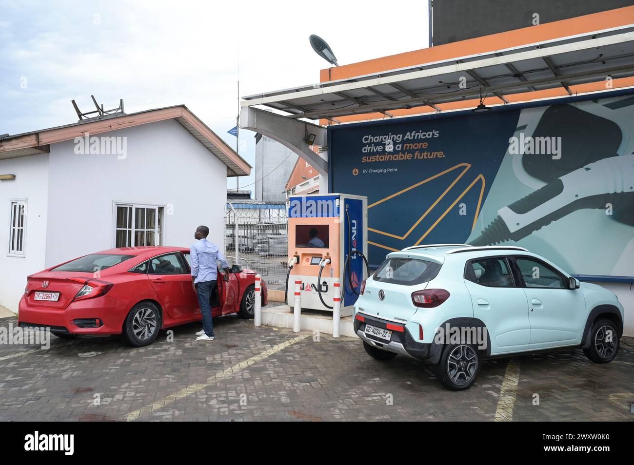 GHANA, Accra, electric mobility, IJANU service and quick charging station for electric cars, charging of chinese Dongfeng EX1 electric car / GHANA, Accra, E-Mobilität, IJANU Service und Ladestation für E-Autos, rechts chinesisches Dongfeng EX1 E-Auto Stock Photo
