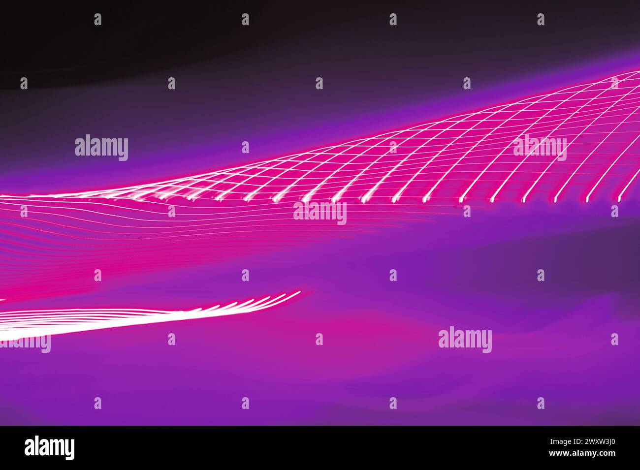 Neon pink light trails motion blurred twisting tunnel Stock Photo