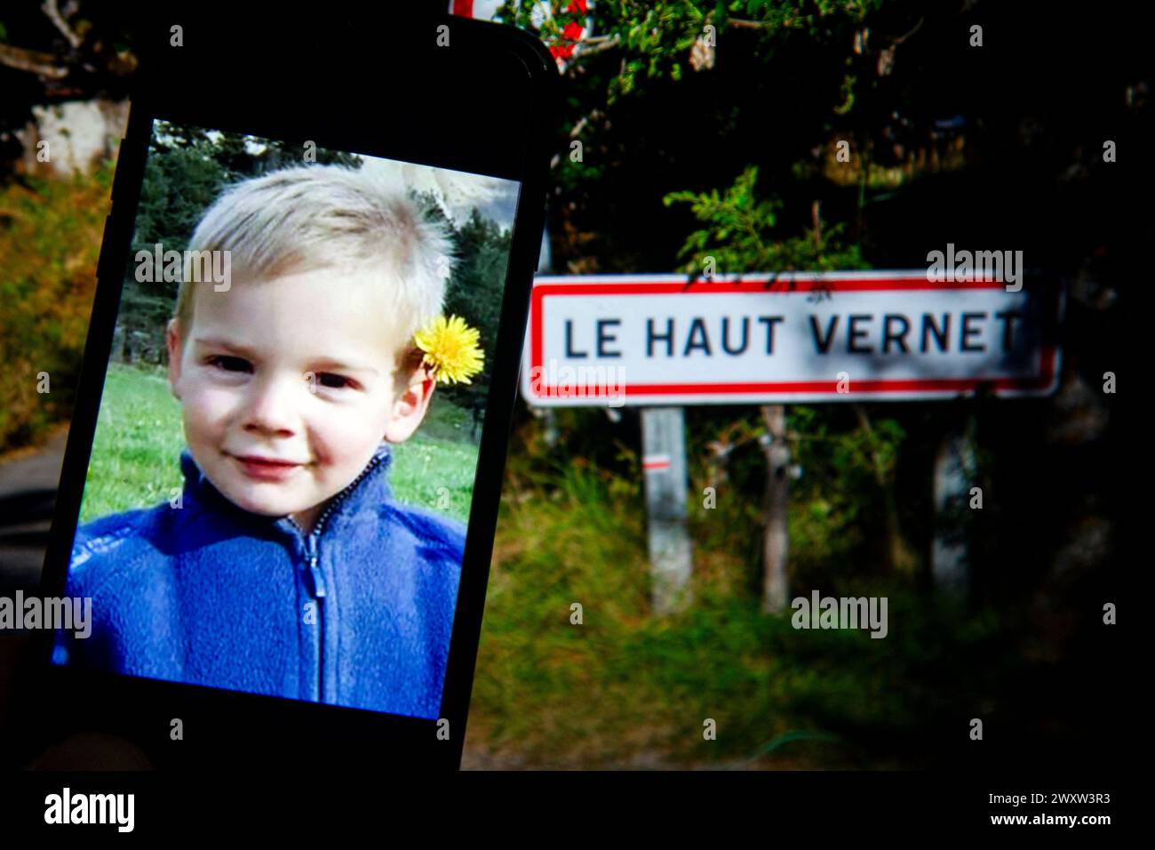 Le Vernet, France. 02nd Apr, 2024. Photomontage with a photograph of little Emile on a phone with the road sign indicating the entrance to the Haut-Vernet hamlet in the background, France, on April 2, 2024. Photo by Thibaut Durand/ABACAPRESS.COM Credit: Abaca Press/Alamy Live News Stock Photo