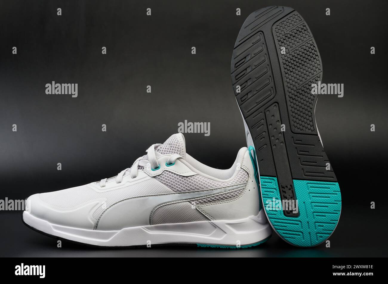 White sport shoes with black sole on studio background close up view