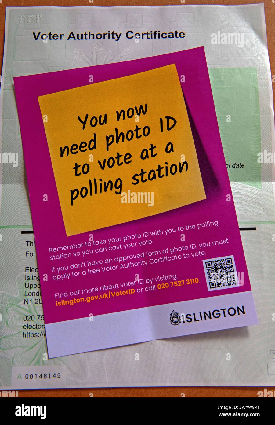 Voter Authority Certificate behind leaflet reminding voters they need photo ID to vote at a polling station Stock Photo