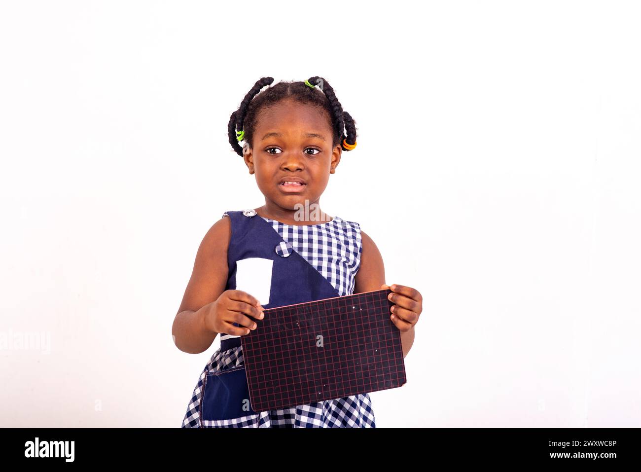 cute little girl dressed in school clothes disgruntled holding a slate ...