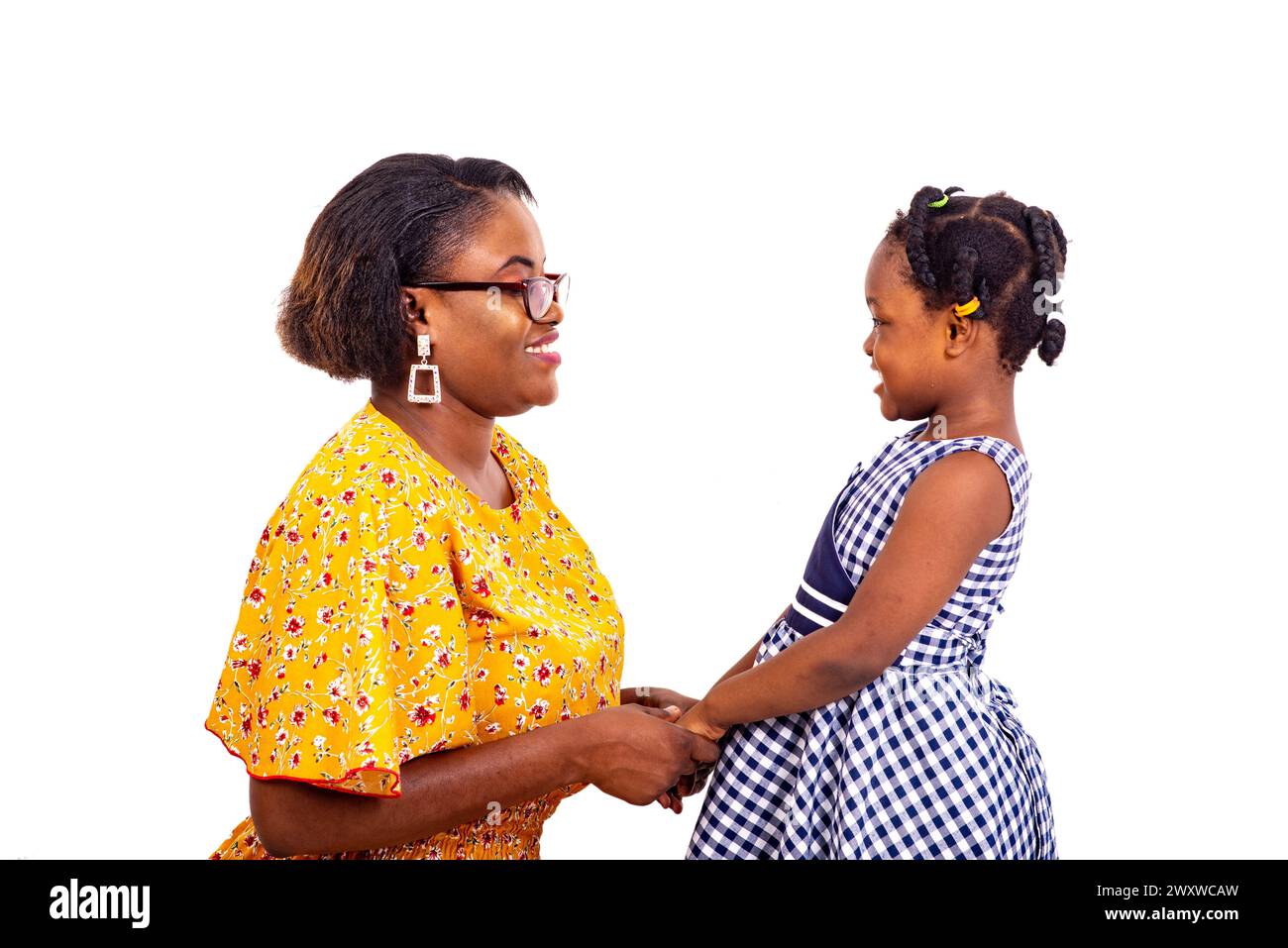 housewife talking with her little daughter in school clothes before going to school while smiling. Stock Photo