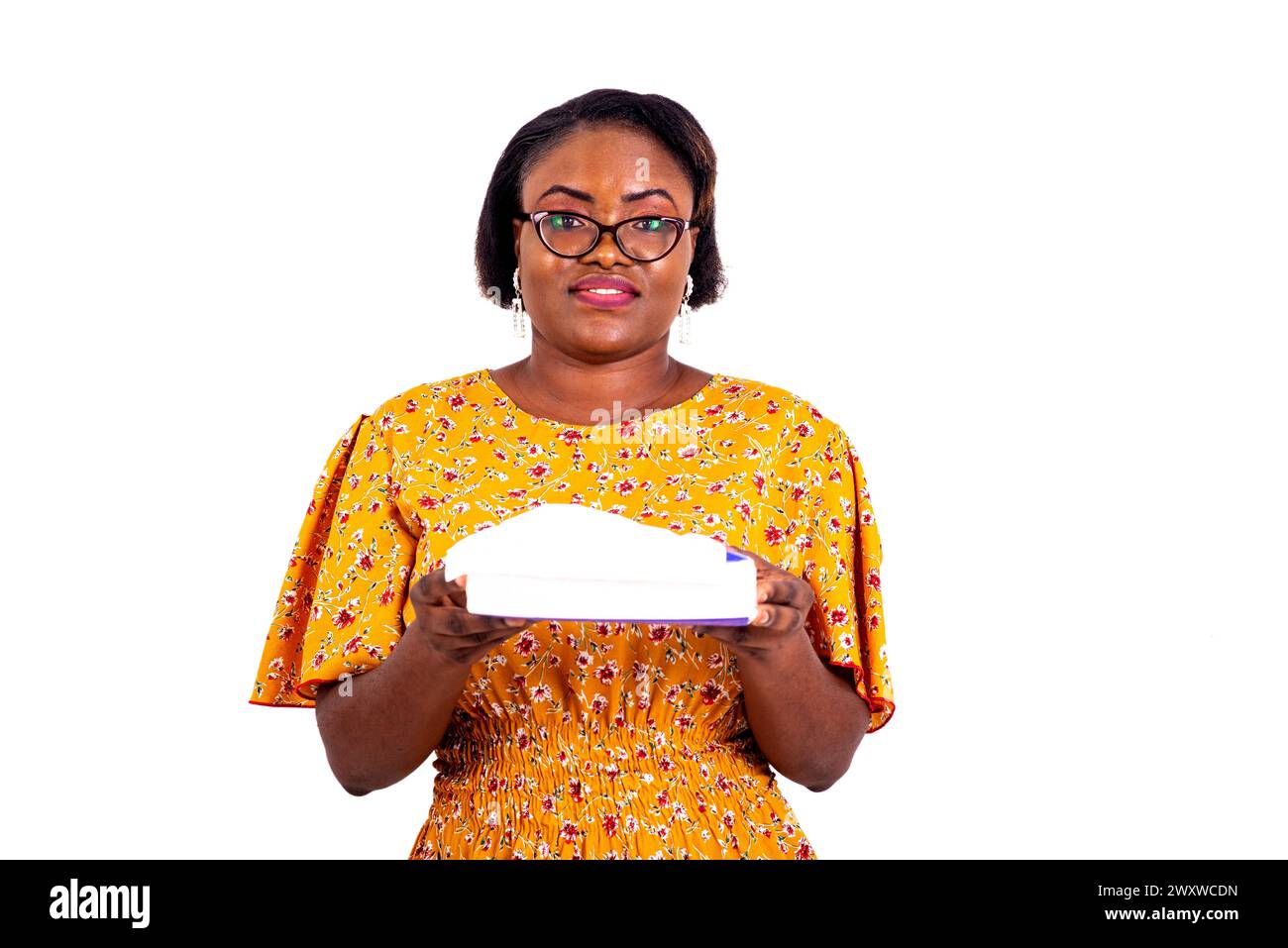 a charming businesswoman in eyeglasses standing against white background holding a bundle of tissue while looking at the camera smiling. Stock Photo