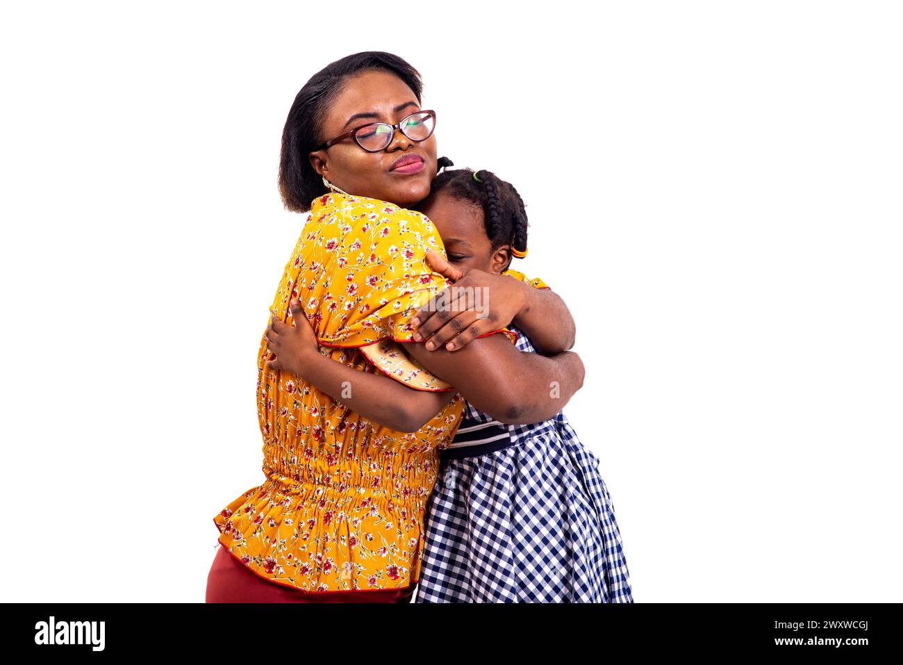 a charming businesswoman in glasses kneeling on white background hugging her daughter. Stock Photo