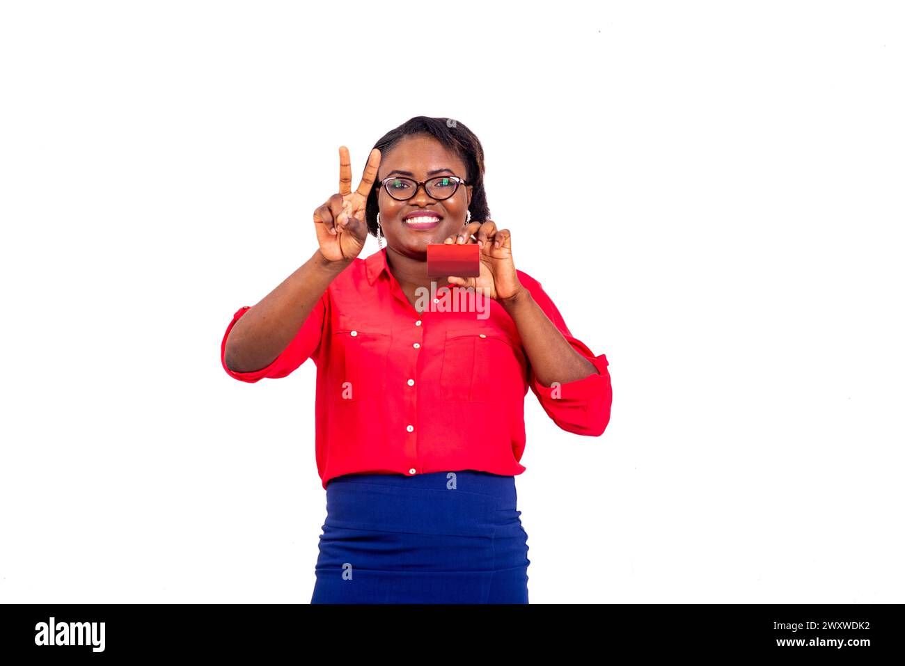 beautiful adult business woman wearing optical glasses holding credit card and making victory sign with fingers while smiling. Stock Photo
