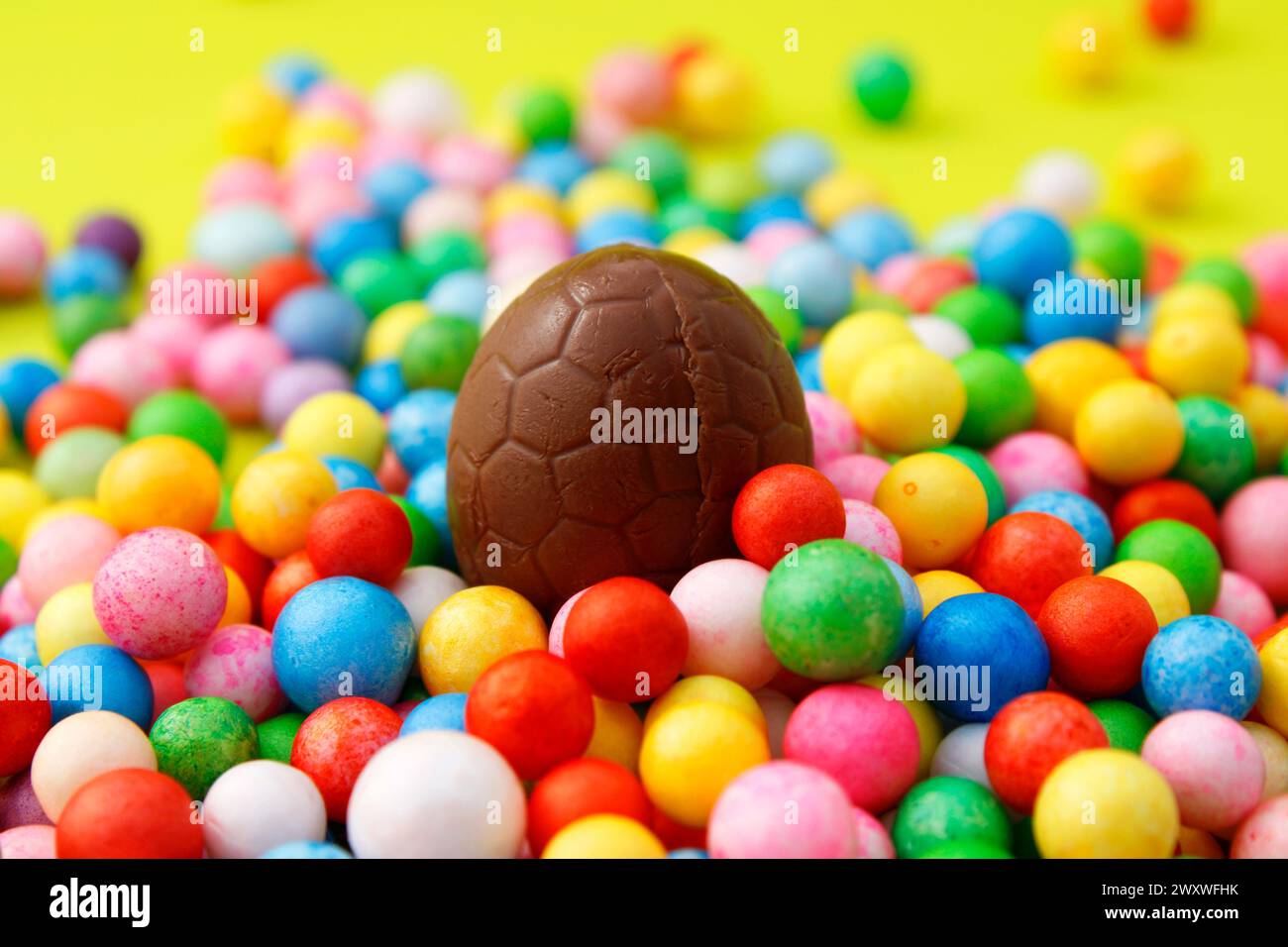 Chocolate Easter egg surrounded by colorful spheres Stock Photo